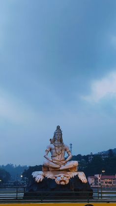 there is a statue on top of the building in front of some trees and buildings