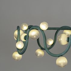 a green chandelier with white balls hanging from it