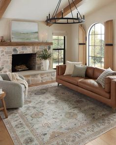 a living room filled with furniture and a fire place in the middle of an open floor plan