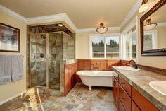 a large bathroom with two sinks and a bathtub in the middle of the room