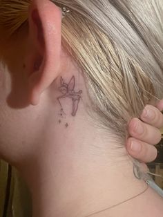 a woman with a small tattoo behind her ear