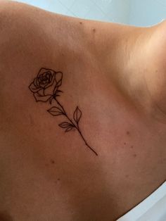 a woman's chest with a rose tattoo on it