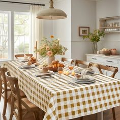 a dining room table is set with plates and cups