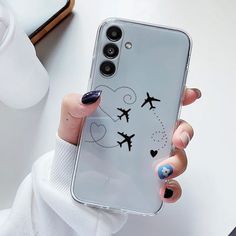 a woman's hand holding an iphone case with airplanes drawn on it