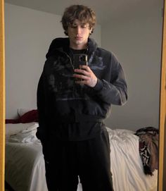 a man taking a selfie in front of a mirror while wearing black sweatpants