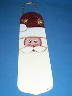 a wooden santa claus ornament on a blue background