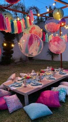 a table set up for a party with balloons and streamers