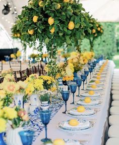 the table is set with lemons and blue glassware for an elegant dinner party