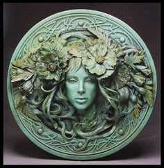 a green plate with a woman's face surrounded by flowers