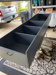 an open toolbox sitting on top of a rug next to a pile of wood