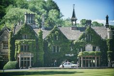 a car parked in front of a large building covered in ivy