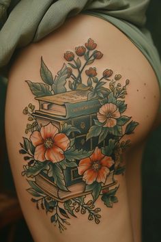 the back of a woman's thigh with flowers and books on it