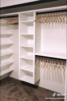 the closet is full of white shelves and hooks for clothes or other things to hang on