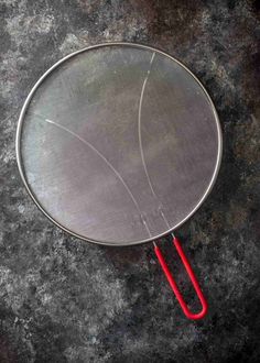 a metal pan with a red handle sitting on top of a table