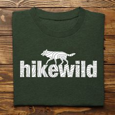 INTRODUCING the "HIKE WILD" Collection. Three illustrated designs in three different colors specifically designed for hikers who love wildlife and appreciate topography maps and contour lines. Proudly designed, printed and shipped from the the Midwest USA... our adult t-shirts are made on Bella + Canvas 3001 Unisex Pre-Shrunk shirts with superior fabric and a soft feel. They are ultra lightweight and flexible for perfect casual wear or casual hikes. EmBlaze Your Trail Hike Wild T-shirts also inc Green Graphic Print T-shirt For Hiking, Green Printed T-shirt For Outdoor Activities, Topography Map, Yellowstone Vacation, Contour Lines, Contour Line, Hiking Tshirt, Wild Wolf, Yellowstone National