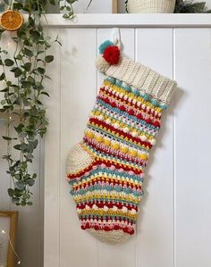 a christmas stocking hanging on the wall next to a potted plant and other decorations