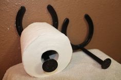 a roll of toilet paper sitting on top of a towel rack next to a pair of scissors