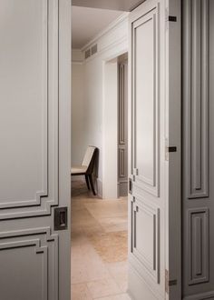 an open door leading to a room with white walls and beige flooring on the other side