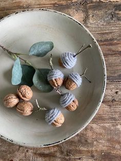 a white bowl filled with nuts and leaves