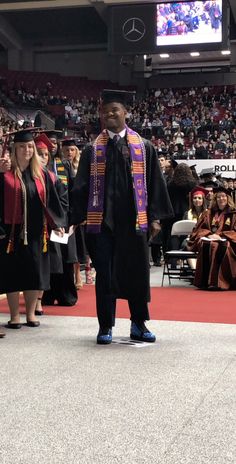 a man standing in front of a crowd at graduation