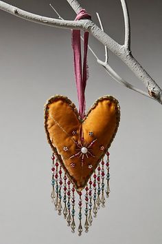 a heart shaped ornament hanging from a tree branch