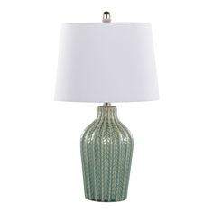 a green ceramic lamp with a white shade on the base and a light bulb attached to it