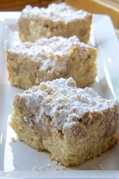 three pieces of cake sitting on top of a white plate with powdered sugar toppings