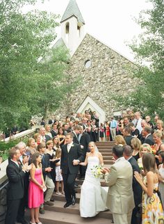 a bride and groom walking down the steps at their wedding