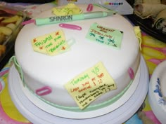 a white cake with writing on it sitting on top of a table