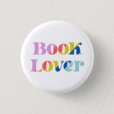 a white button with the words book lover printed in multicolored letters on it