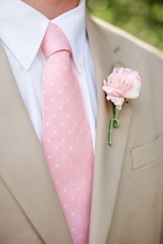 a man in a suit and tie with a pink flower