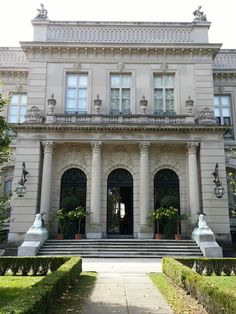 the front entrance to a large building with many windows and columns on either side of it