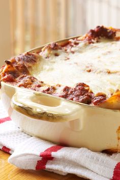 a casserole dish with meat and cheese in it on a red and white towel