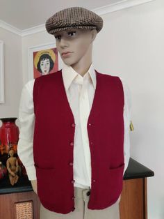 This is a handknit wool vest in a great cherry red colour and is a small size. The vest has a button front and two hip pockets. The condition is very good Measurements are Chest 102cm Length shoulder to hem 61cm Classic Red Winter Vest, Red Wool Vest For Winter, Classic Red Vest For Fall, Classic Winter Sweater Vest With Pockets, Classic Red Sleeveless Vest, Red Vest With Pockets, Red Sleeveless Vest With Pockets, Cherry Red Colour, Sleeveless Sweaters