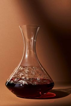 a glass vase filled with liquid sitting on top of a brown tablecloth covered floor