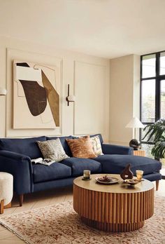 a living room with a blue couch and coffee table in front of a large window