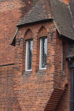 a red brick building with two windows on the side