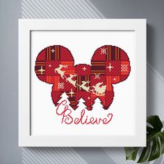 a cross stitch mickey mouse with the word believe