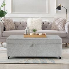 a living room with a couch, ottoman and coffee table