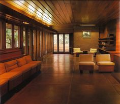 a living room filled with lots of furniture next to tall wooden walls and flooring