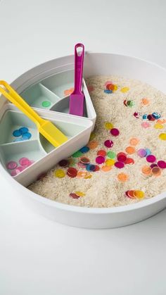 a white bowl filled with rice and colorful utensils