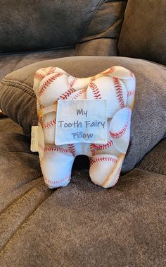 a tooth fairy pillow sitting on top of a couch