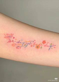 a woman's arm with flowers and writing on it