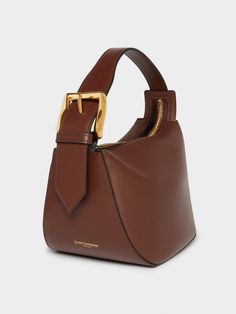 A new addition to the Quiver family, this dynamic-shaped bag is made from Wine smooth-calf leather. It has a simple zip closure and robust handle and features J&M D's statement brass buckle, and comes with a long detachable strap as well. H 14cm, W 22cm, D 16.5cm. Strap drop 55cm Buckle Bag, Clever Gift, Fall Denim, Transparent Bag, Statement Bag, Fancy Bags, Quiver, Brass Buckle, Stocking Fillers