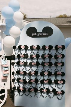 a mickey mouse themed birthday party with balloons and streamers on the side of it