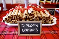 there is a sign that says diploma cookies in front of some other items on the table