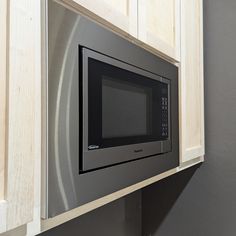 a microwave built into the side of a kitchen cabinet