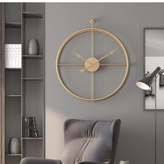 a living room with a gray chair and a clock on the wall above it's head