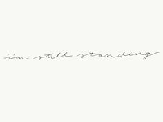 the words i'm still standing are written in cursive handwriting on a white background