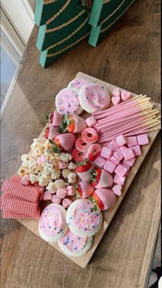 a wooden table topped with lots of candy and marshmallows